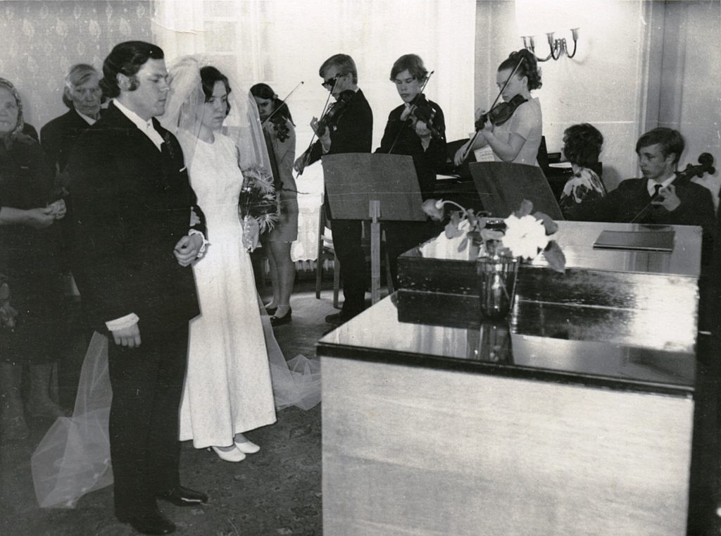 Juta ja Tiit Helilaiu abiellumine 1970. aastal. Taustal välgutavad viiulit tulevased oma ala tipptegijad – Mari Tampere, Andres Mustonen ja Paul Mägi. Foto erakogu